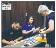 ?? Special to the Arkansas Democrat-Gazette ?? A woman makes a transactio­n at the “Pawn Shop” booth during last week’s poverty simulation at the University of Central Arkansas in Conway. The event was aimed at helping people better understand poverty.