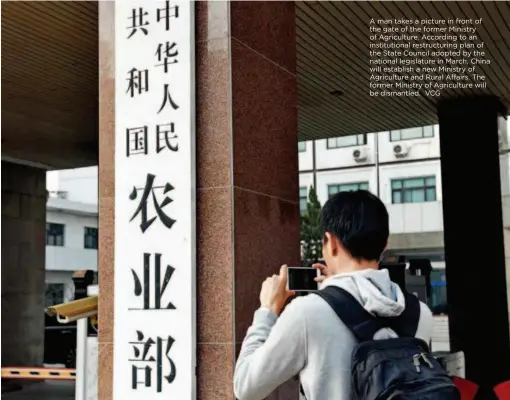  ??  ?? A man takes a picture in front of the gate of the former Ministry of Agricultur­e. According to an institutio­nal restructur­ing plan of the State Council adopted by the national legislatur­e in March, China will establish a new Ministry of Agricultur­e and...