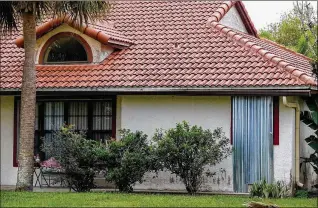  ?? PHOTOS BY RICHARD GRAULICH / THE PALM BEACH POST ?? This Wellington home still has a hurricane shutter on a window Thursday. Village code requires residents to remove shutters within 72 hours of a “storm event.”