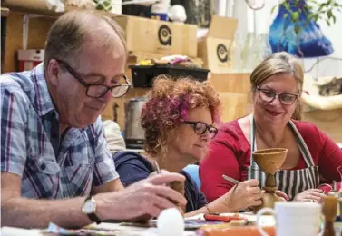  ??  ?? Above: Nick, Carmen, and another workshop participan­t refining wax moulds using worn dental instrument­s