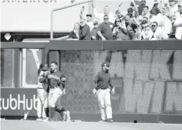  ?? MIKE STOBE TNS ?? Cleveland’s Oscar Mercado is restrained as fans at Yankee Stadium throw debris on the field Saturday after a walk-off single by New York’s Gleyber Torres in the ninth.