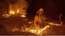  ?? Noah Berger, The Associated Press ?? While battling the Caldor fire, firefighte­rs burn vegetation to create a control line along U.S. 50 in Eldorado National Forest, Calif., on Thursday.