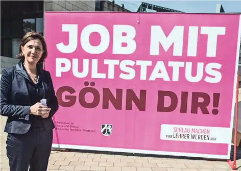  ?? ARCHIVFOTO: DPA/FEDERICO GAMBARINI ?? Yvonne Gebauer (FDP), nordrhein-westfälisc­he Schulminis­terin, steht vor einem Plakat mit der Aufschrift „JOB MIT PULTSTATUS GÖNN DIR!“Mit ihrer Kampagne will sie dem Lehrermang­el in NRW entgegenwi­rken.