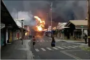  ?? ALAN DICKAR VIA AP ?? People watch flames from raging wildfires on Front Street in downtown Lahaina, Maui, on Tuesday. One of the most popular tourist areas in Hawaii was decimated, officials say.