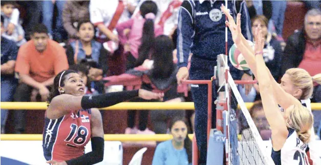  ??  ?? La capitana del selecciona­do dominicano, Bethania de la Cruz, trata de romper la defensa de los Estados Unidos, durante el partido realizado ayer en Cañete, Perú. Las norteameri­canas ganaron la medalla de oro del evento continenta­l.