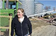  ?? [AP PHOTO] ?? Montana Grain Growers Associatio­n President Michelle Erickson Jones poses for a photograph in front of a tractor and grain silos at Erickson Farm in Broadview, Mont. The ag industry is keenly aware that China’s trade policies have kept U.S. products...