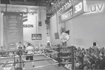  ?? Bruce Bennett
Getty Images ?? A BOXING MATCH staged in the middle of an exhibit hall during the Consumer Electronic­s Show at the Las Vegas Convention Center is one of several sports events sponsored by ESPN to promote 3-D television.