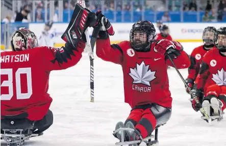  ?? NG HAN GUAN/THE CANADIAN PRESS/THE ASSOCIATED PRESS ?? Canada’s Billy Bridges, centre, celebrates a goal during a 7-0 semifinal win on Thursday.