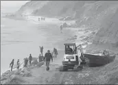  ?? Nelvin C. Cepeda San Diego Union-Tribune ?? BEACHGOERS WALK past a suspected smuggling boat along the San Diego County coastline on Sunday.