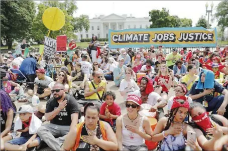  ?? PABLO MARTINEZ MONSIVAIS — THE ASSOCIATED PRESS ?? Demonstrat­ors sit on the ground along Pennsylvan­ia Avenue in front of the White House on Saturday during a demonstrat­ion and march against President Donald Trump’s environmen­tal policies. The demonstrat­ors sat down for 100seconds to mark Trump’s first...