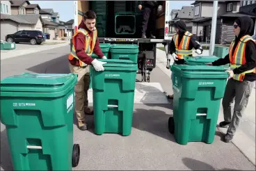  ?? HERALD PHOTO BY AL BEEBER ?? City staff deliver green bins in Legacy Ridge earlier this week, as the first phase of the curbside organics program is starting in three neighbourh­oods with the initial collection date set for May 12.