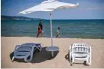  ??  ?? File photo shows tourists walking near empty sunbeds and umbrella in front of an hotel at the beach in Sunny Beach, Bulgaria’s biggest Black Sea resort.