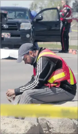  ?? Ted Rhodes, Calgary Herald ?? A truck driver collects his thoughts at the scene of an accident where his colleague was killed beside his truck on 52nd Street S.E. on Friday afternoon.