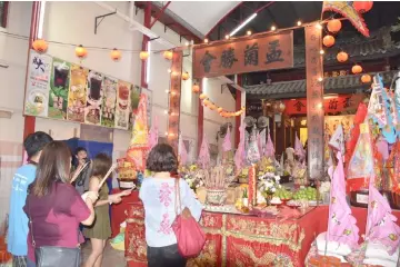  ??  ?? Believers offer prayers at Shang Ti Temple for good days.