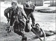  ?? Picture: JUHAN KUUS ?? FORTITUDE: A policeman drags a Gugulethu man shot during the uprising. The picture is part of the 1976/360 exhibition at the University of Cape Town’s Centre for African Studies gallery