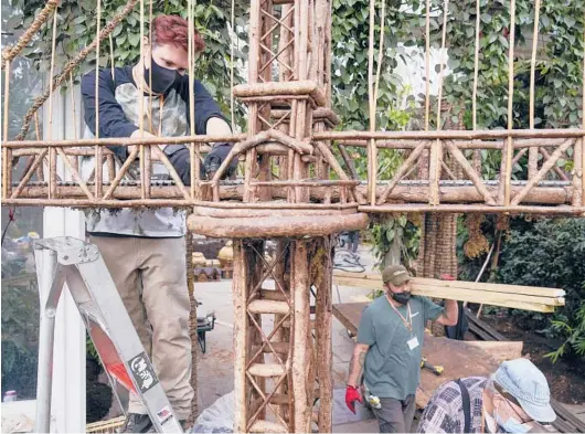  ?? SETH WENIG/AP PHOTOS ?? Kieran Beam, left, works on train tracks on Nov. 11 as part of preparatio­ns for the annual Holiday Train Show at the New York Botanical Garden in New York.