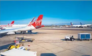  ?? Smith Collection/Gado/Getty Images ?? SINCE LAUNCHING in 2007, Virgin America has developed a devoted following and won several consumer awards from travel magazines. Above, jets on the tarmac at Los Angeles Internatio­nal Airport in November.