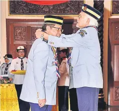  ??  ?? Abang Johari (left) receives the ‘Bintang Semangat Padi Perak’ from Taib at Astana Negeri.