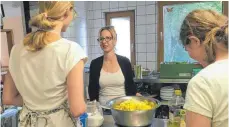  ?? FOTO: YVONNE ROITHER ?? Küchendien­st: Dominique Klappoth, Leiterin der therapeuti­schen Gemeinscha­ft Haus Weizenkorn, im Gespräch mit zwei jungen Frauen, die gerade das Mittagesse­n zubereiten.