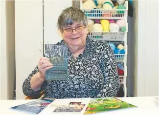  ?? ?? Cheryl Price, formerly of Wheaton, holds her recently published memoir, “Through the Woods,” offering inspiratio­n to those who also face physical challenges in life.