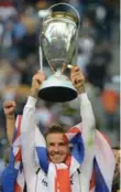  ?? ROBYN BECK/AFP/GETTY IMAGES ?? David Beckham hoists the MLS Trophy after his final game for L.A.