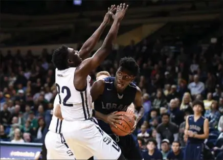  ?? ERIC BONZAR — THE MORNING JOURNAL ?? Lorain forward Taevon Pierre-Louis bodies his way past Toledo St. John’s Vincent Williams Jr. on March 17 in Toledo.