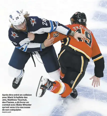  ?? PHOTO AFP ?? Après être entré en collision avec Mark Scheifele des Jets, Matthew Tkachuk, des Flames, a dû livrer un combat avec Blake Wheeler qui est venu à la rescousse de son coéquipier.