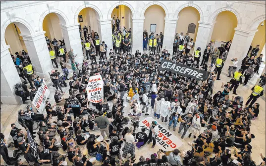  ?? Amanda Andrade-rhoades The Associated Press ?? Demonstrat­ors, calling for a cease-fire in the ongoing war between Israel and Hamas, chant and hold banners during a protest Wednesday inside the Cannon House Office Building at the U.S. Capitol. More than 300 people were arrested.