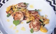  ?? RICK WOOD / MILWAUKEE JOURNAL SENTINEL ?? Scallops with Summer Veggies includes corn, zucchini and yellow squash.