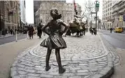  ?? MARK LENNIHAN/THE ASSOCIATED PRESS ?? Fearless Girl faces down Wall Street’s iconic bull. The world of finance is still very much a boys club.