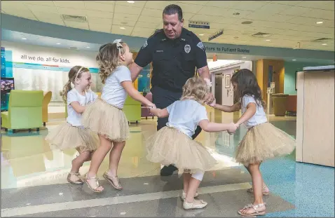  ?? (Courtesy Photo/Allyn DiVito/John Hopkins All Children’s Hospital) ?? Security guard David Dean dances in August 2018 with McKinley Moore, Avalynn Luciano, Lauren Glynn and Chloe Grimes at the hospital in St. Petersburg, Fla. The girls, who were diagnosed with cancer in 2016 and became fast friends while undergoing treatment, reunite every year.