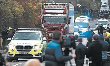  ?? ALASTAIR GRANT/AP ?? Police escort the tractor-trailer Wednesday from an industrial park in southeaste­rn England. The 25-year-old driver was arrested on suspicion of murder in the smuggling case.