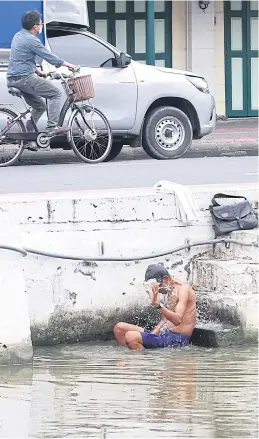  ?? ?? SAFER THAN A SWIM: A young man takes a dip in Klong Lod along Atsadang Road after the canal’s water quality improved and the surroundin­g areas were spruced up.