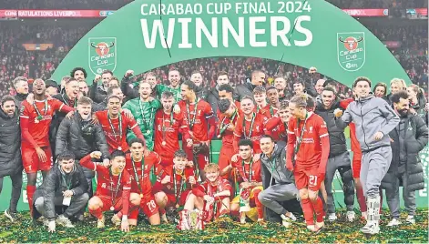  ?? — AFP photo ?? Liverpool players pose with the trophy after the English League Cup final football match between Chelsea and Liverpool at Wembley stadium.