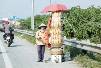  ?? (Kham/Reuters) ?? A WOMAN displays bread for sale yesterday on a roadside in Hanoi, Vietnam. MSCI’s world equity index, which tracks shares in 47 countries, gained 0.08% to top the record hit last Monday.