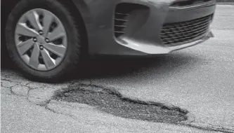  ?? KEITH GOSSE • THE TELEGRAM ?? A car approaches a pothole on Lemarchant Road in St. John’s.