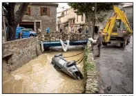  ?? AP/FRED LANCELOT ?? People try to pull a car out of the water Monday after flash flooding in the town of Villegailh­enc, France.