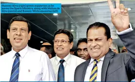  ??  ?? Shammi Silva (right) greets supporters as he leaves the Sports Ministry, along with Mohan de Silva (centre) and Raveen Wickramara­tne (left)