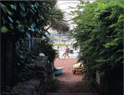  ??  ?? A man walks along the beach July 20 in Shaldon.