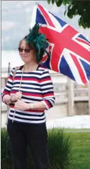  ?? ?? Maggie Brooks waves her British flag during Peachland's celebratio­n of the Queen's Platinum Jubilee held at the Rotary Plaza gazebo in Heritage Park Thursday afternoon.