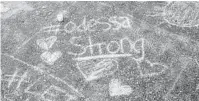  ?? CENGIZ YAR/GETTY ?? A chalk message at a memorial for victims of a mass shooting, at the University of Texas of the Permian Basin on Monday in Odessa, Texas. Officials say the suspect is dead after he killed 7 people and injured 22.