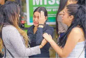  ??  ?? Family members speak with 16-year-old Alondra Lopez, a server at Lin’s Buffet who was working Sunday during what police describe as a “hostage situation.”