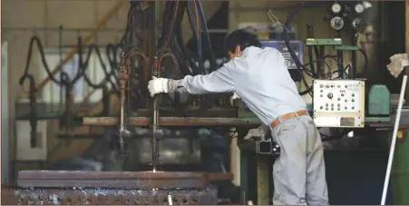  ??  ?? A man works around a metal procession machine at a factory in Urayasu, east of Tokyo. Japan’s core machinery orders, a highly volatile data series regarded as an indicator of capital spending in the coming six to nine months, fell 2.4% in August from the previous month, Cabinet Office data showed yesterday.