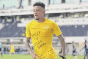  ?? Lars Baron / POOL / AFP via Getty Images ?? Dortmund’s English midfielder Jadon Sancho shows a “Justice for George Floyd” shirt as he celebrates after a goal in a Bundesliga match.