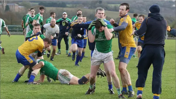  ??  ?? Top scorer Cormac O’Rourke (15) taking evasive action in a shameful scene which marred Saturday’s Leinster Club encounter in St. Patrick’s Park, Enniscorth­y.