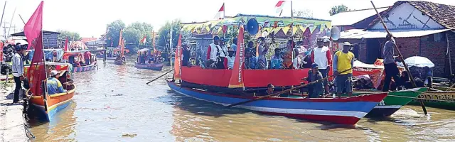  ?? BOY SLAMET/JAWA POS ?? RITUAL TAHUNAN: Iring-iringan perahu nelayan warga Dusun Gisik Cemandi menuju laut untuk melarung sesaji kemarin. Kegiatan tersebut merupakan bentuk syukur warga atas berkah tahun ini.