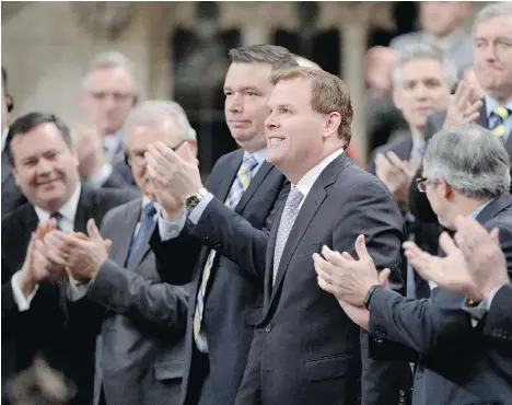  ?? THE CANADIAN PRESS ?? John Baird receives a standing ovation in the House of Commons after announcing his resignatio­n in Ottawa on Tuesday.