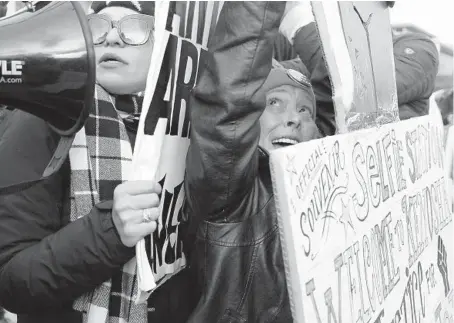  ?? STACEY WESCOTT/CHICAGO TRIBUNE ?? Jennifer Pierce-Miller, right, covers the sign of Emily Cahill, left, as people with opposing views argue outside the Kenosha County Courthouse as the jury deliberate­s about the Kyle Rittenhous­e case on Tuesday in Kenosha.