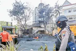  ?? AP ?? A police officer stands guard at one of the sites of church attacks in Surabaya, East Java, Indonesia on Sunday. —