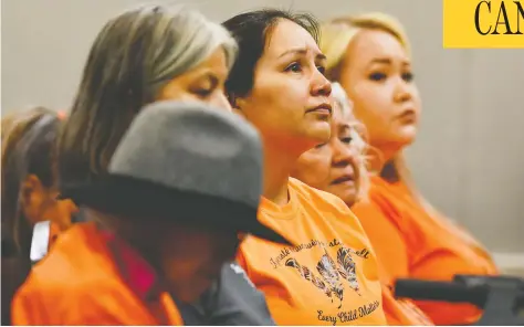  ?? JENNIFER GAUTHIER / REUTERS ?? Indigenous community members react Thursday to a report's findings on the unmarked graves discovered at Kamloops Indian Residentia­l School.
